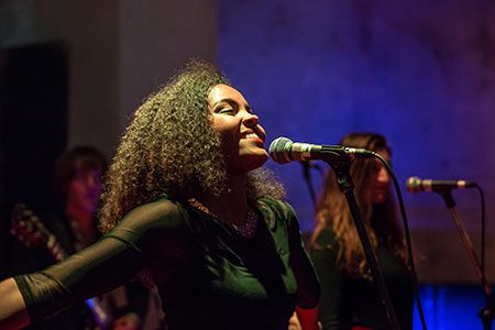 Black, female student singing into a microphone