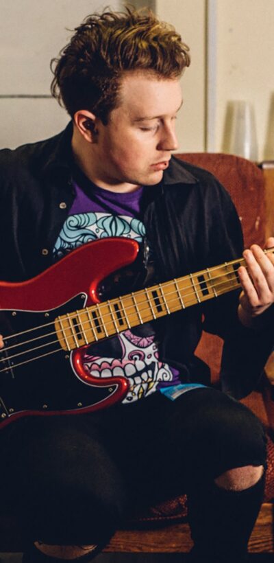 Male student using an electric guitar