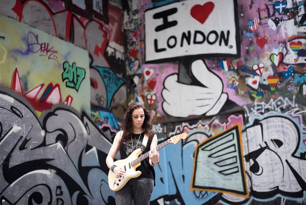 Bimm student on guitar in front of london mural