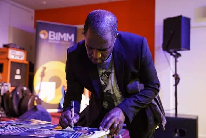 Mo Pleasure signing a paper
