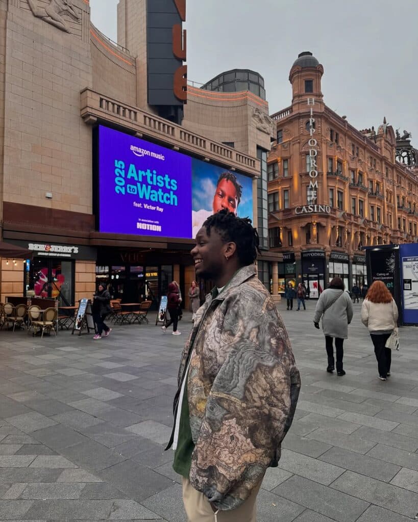 Victor Ray in front of his own marketing banner in the city